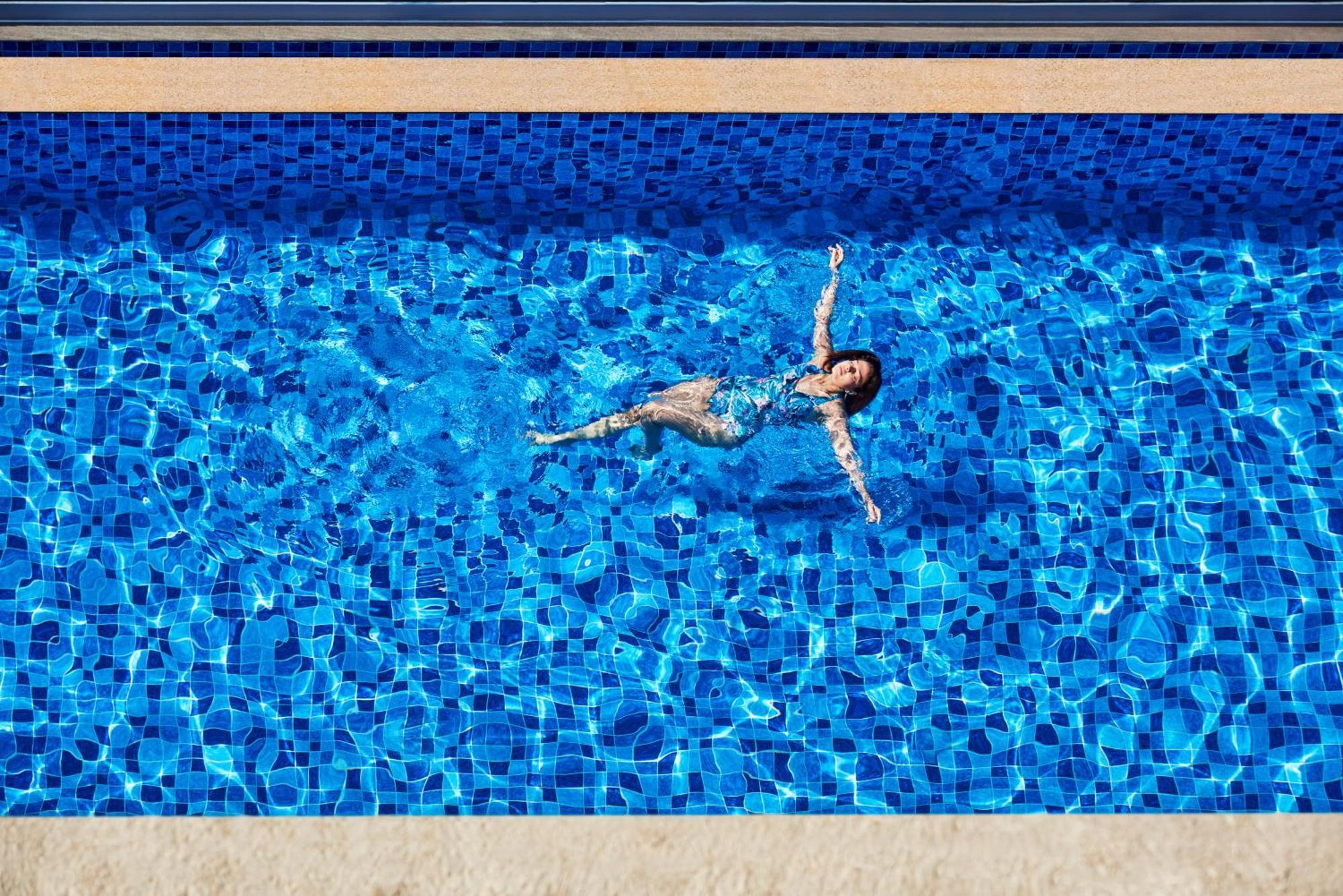 Novotel Mumbai International Airport Exteriör bild A woman floating in a swimming pool