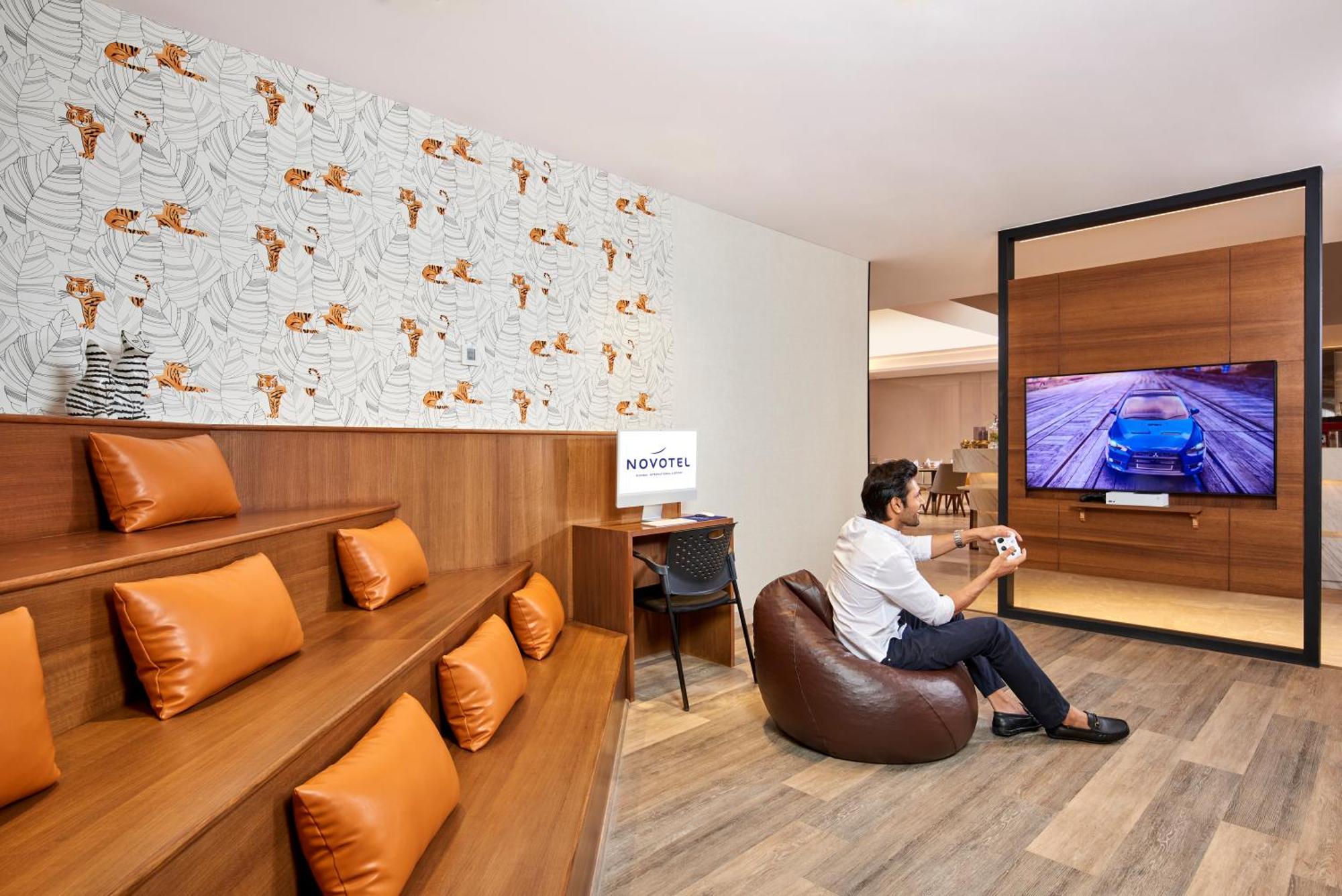 Novotel Mumbai International Airport Exteriör bild A man playing a video game at the lounge