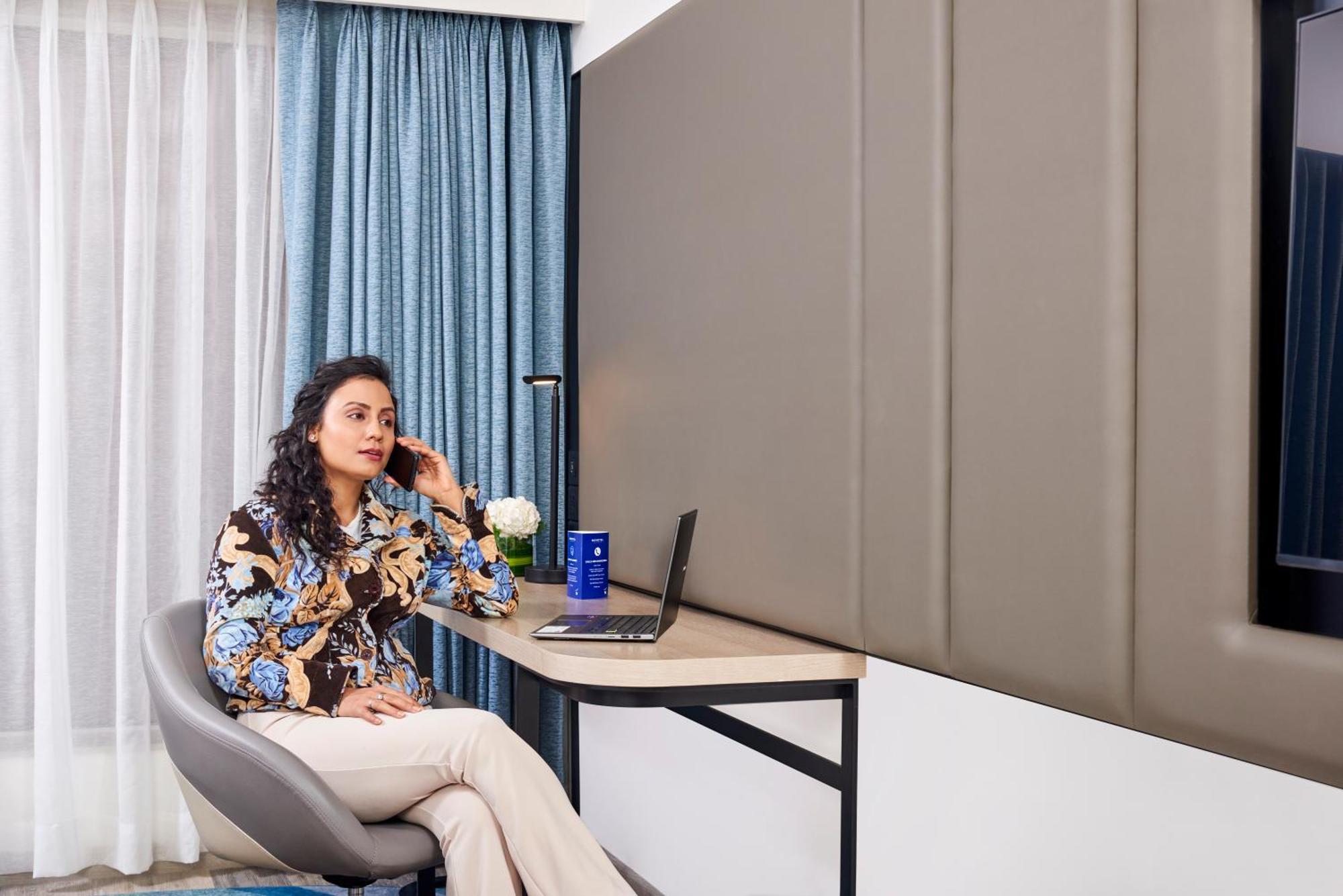 Novotel Mumbai International Airport Exteriör bild A woman working from home